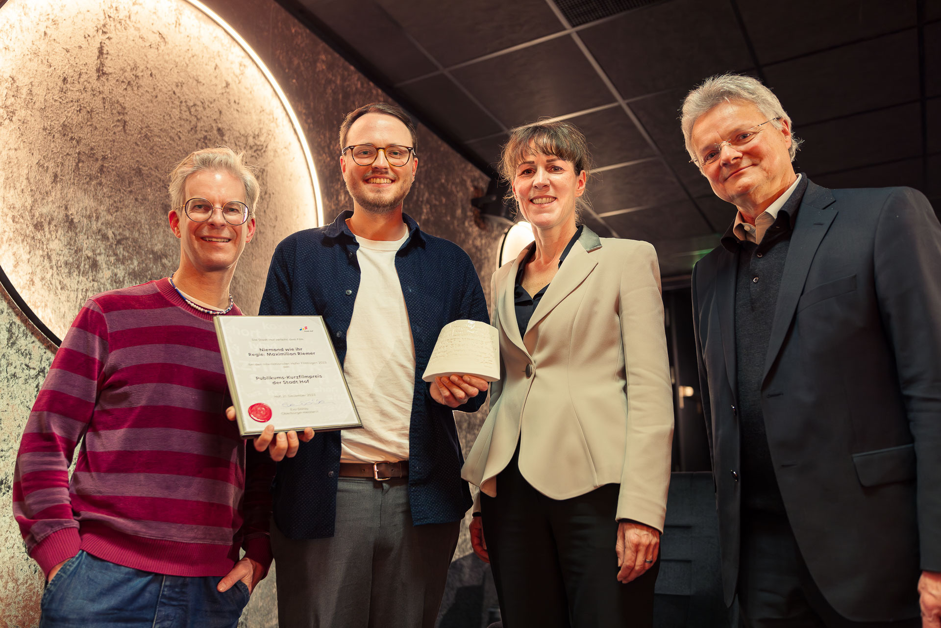 Eva Döhla, Oberbürgermeisterin der Stadt Hof und Kulturamtsleiter Peter Nürmberger übergeben den Publikums-Kurzfilmpreis an Max Riemer für NIEMAND WIE IHR