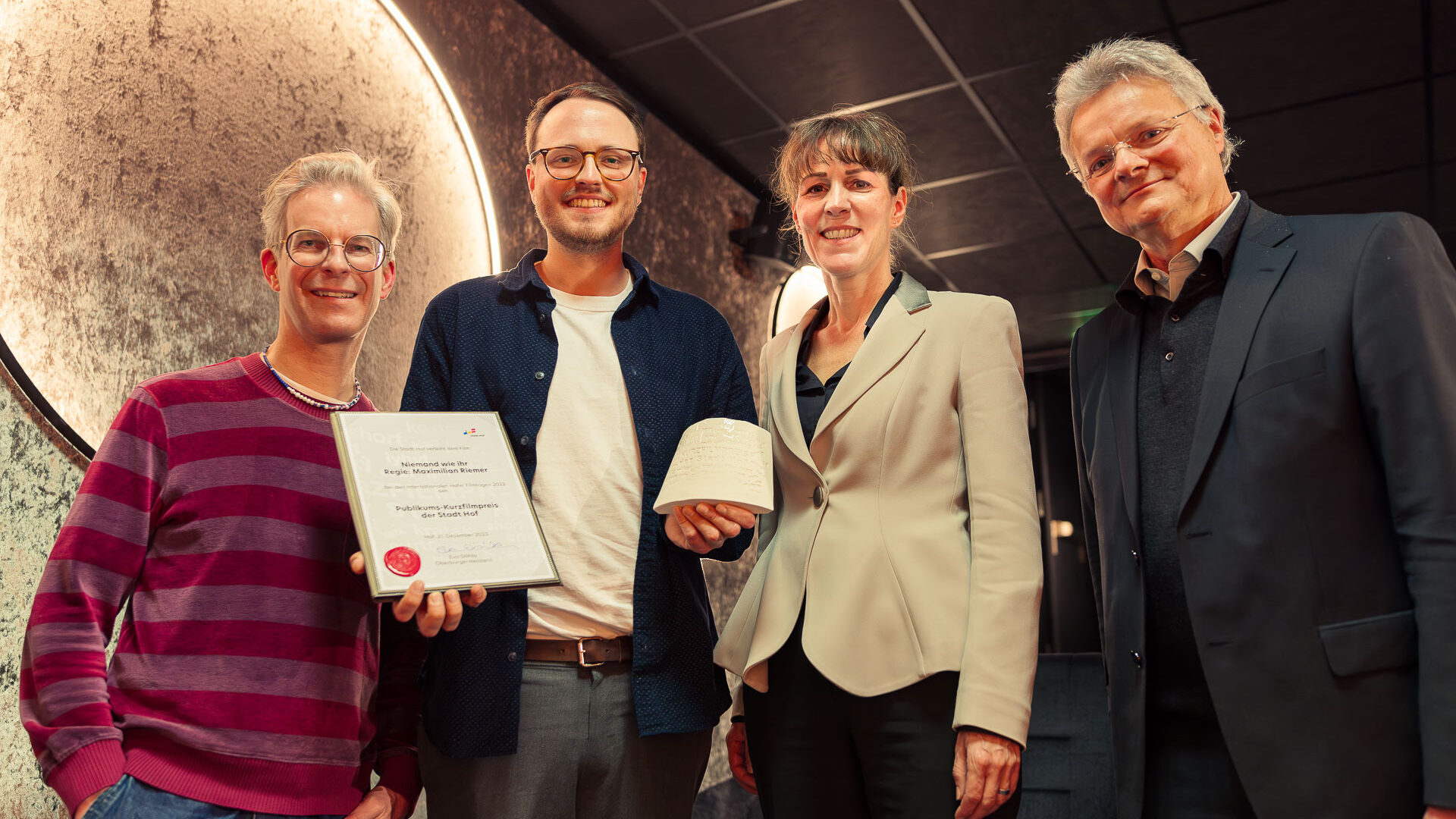 Eva Döhla, Oberbürgermeisterin der Stadt Hof und Kulturamtsleiter Peter Nürmberger übergeben den Publikums-Kurzfilmpreis an Max Riemer für NIEMAND WIE IHR